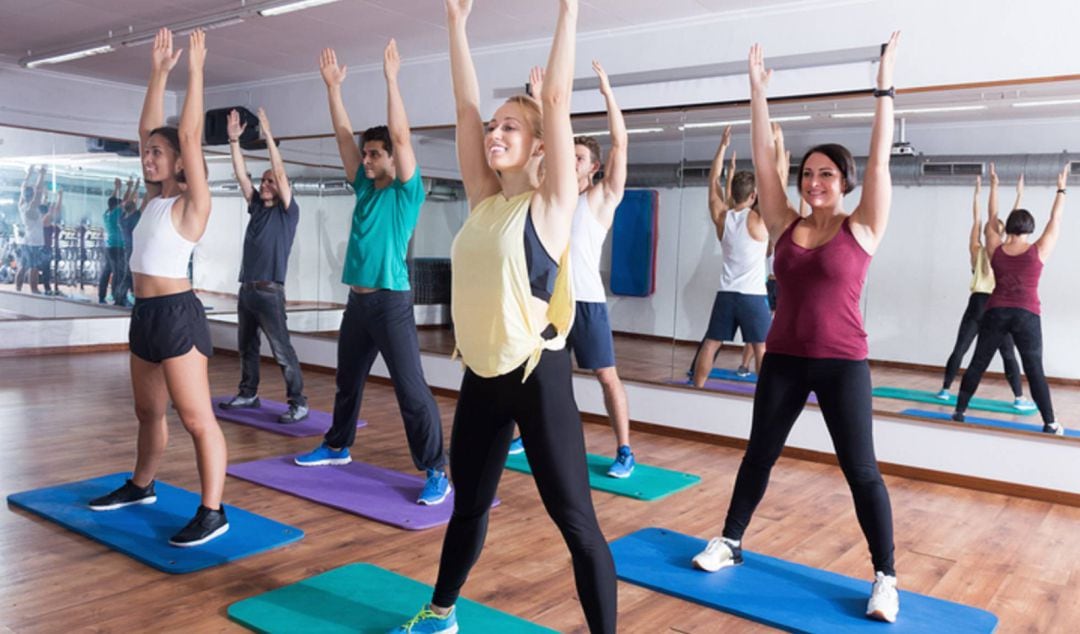 Grupo de personas realizando ejercicios físicos en un gimnasio
