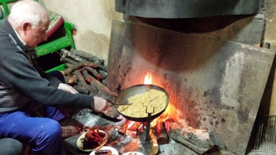 Felipe prepara unas migas en el fuego