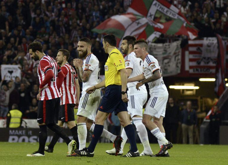 GRA349. BILBAO, 09/04/2015.- El defensa argentino del Valencia, Nicolás Otamendi (3i), conversa con el colegiado Teixeira Vitienes, tras ser expulsado durante el encuentro correspondiente a la jornada 30 de primera división, que han disputado esta noche frente al Ath. de Bilbao en el estadio de San Mamés, Bilbao. EFE / Miguel Toña.