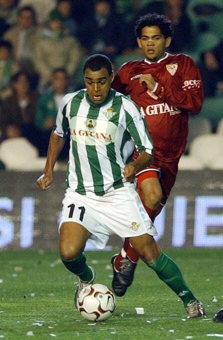 Denilson con el balón ante Dani Alves en un derbi sevillano.