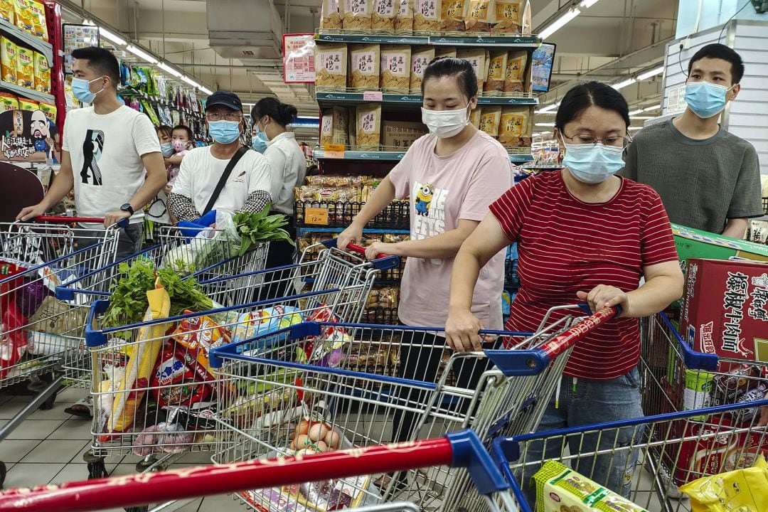 Un grupo de personas hace cola en un supermercado de Wuhan, este martes.