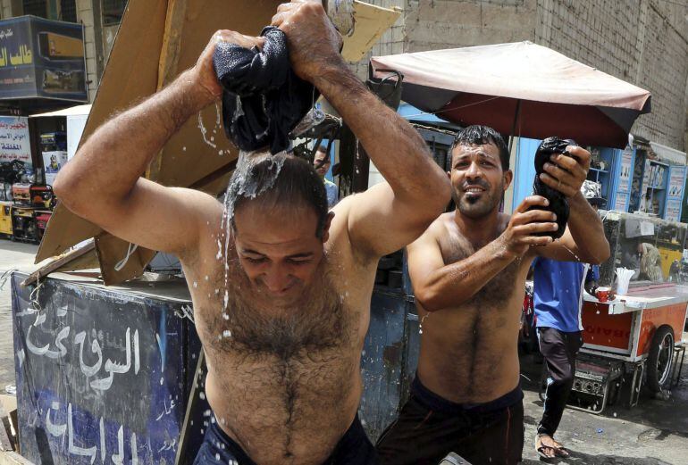 Ciudadanos iraquíes mojan sus ropas para refrescarse, en el centro de Bagdad, el pasado 21 de julio de 2016, con una temperatura de 50 grados centígrados. 