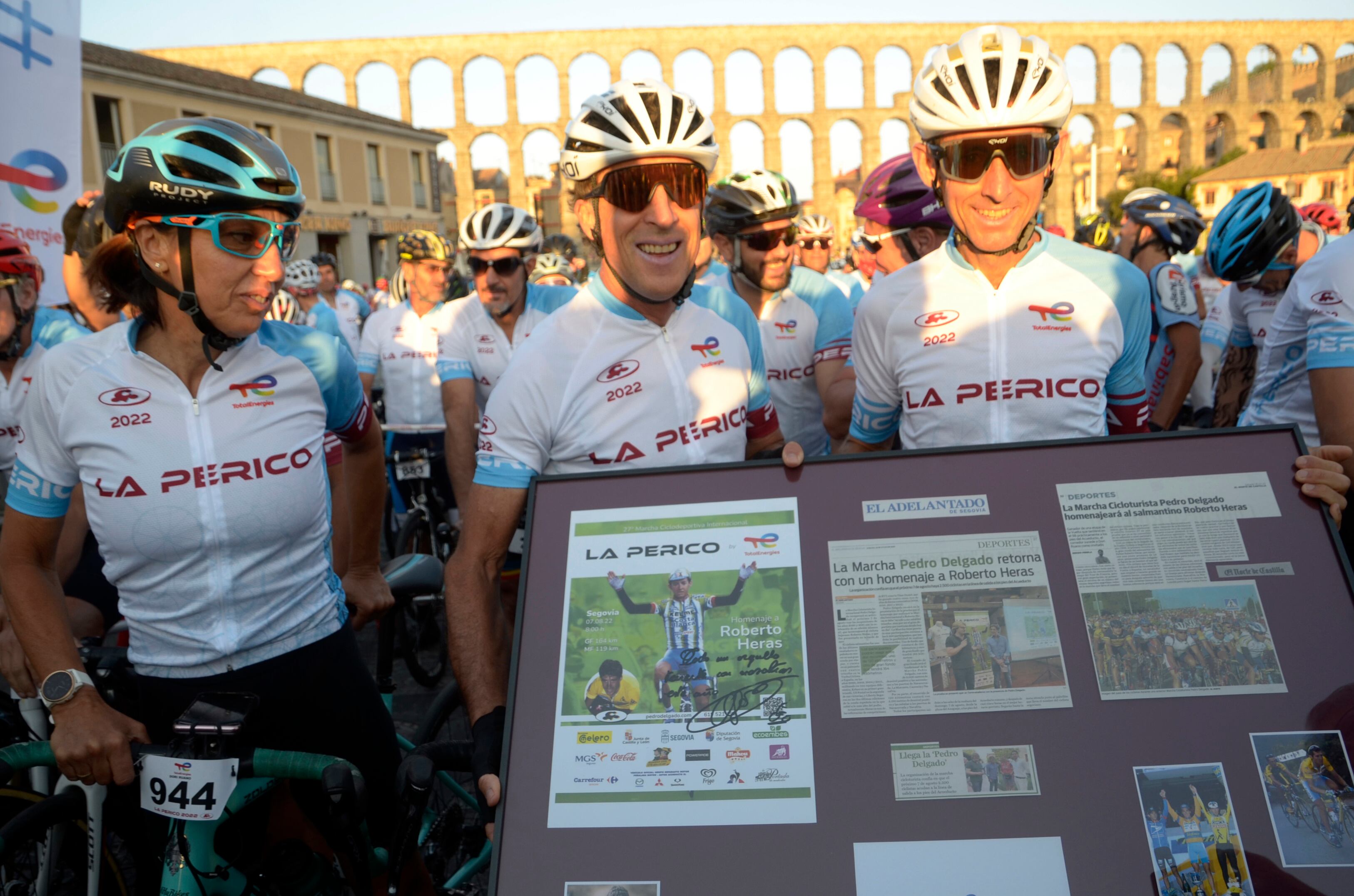 SEGOVIA, 07/08/2022.- El exciclista profesional Roberto Heras (d) recibe un obsequio de manos del también exciclista Pedro Delgado (c) y de la varias veces campeona de España en ruta y contrarreloj Dori Ruano (i), momentos antes de darse la salida de la marcha ciclodeportiva 'La Perico2022' este domingo en Segovia. Con unos 1.500 participantes, tras dos años sin celebrarse, se desarrolla a lo largo de 164 kilómetros y cuatro puertos de montaña para rendir homenaje al exprofesional Roberto Heras, cuatro veces ganador de la Vuelta Ciclista a España. EFE/Pablo Martín