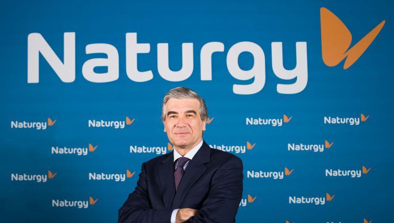 El presidente ejecutivo de Naturgy, Francisco Reynés, junto al nuevo logo de la compañía