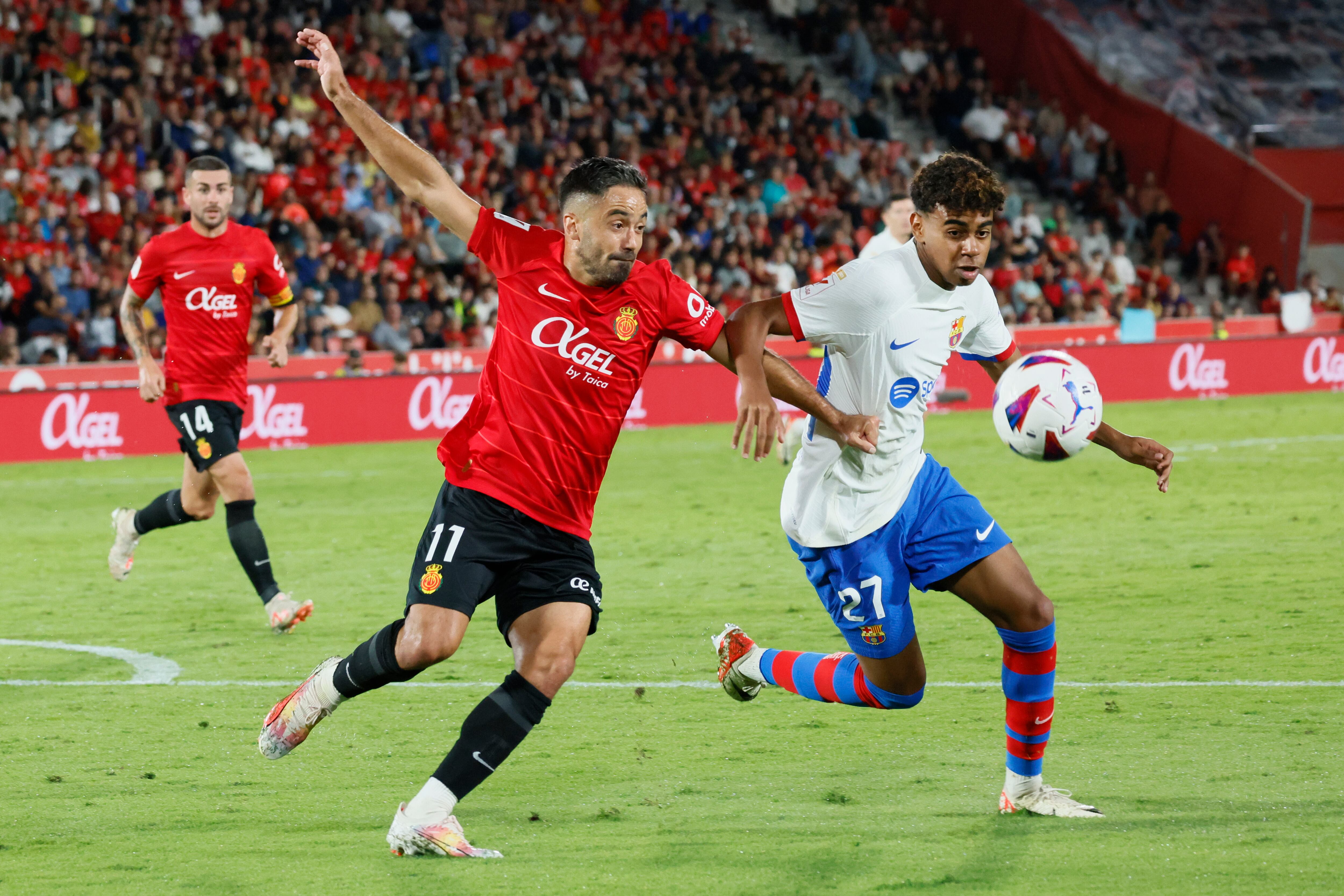 PALMA DE MALLORCA, 26/09/2023.- El delantero del Barcelona Lamine Yamal (d) pelea un balón con Jaume Costa, del Mallorca, durante el partido de la séptima jornada de LaLiga entre el RCD Mallorca y el FC Barcelona que disputan hoy martes en el estadio de Son Moix, en Palma de Mallorca. EFE/Cati Cladera