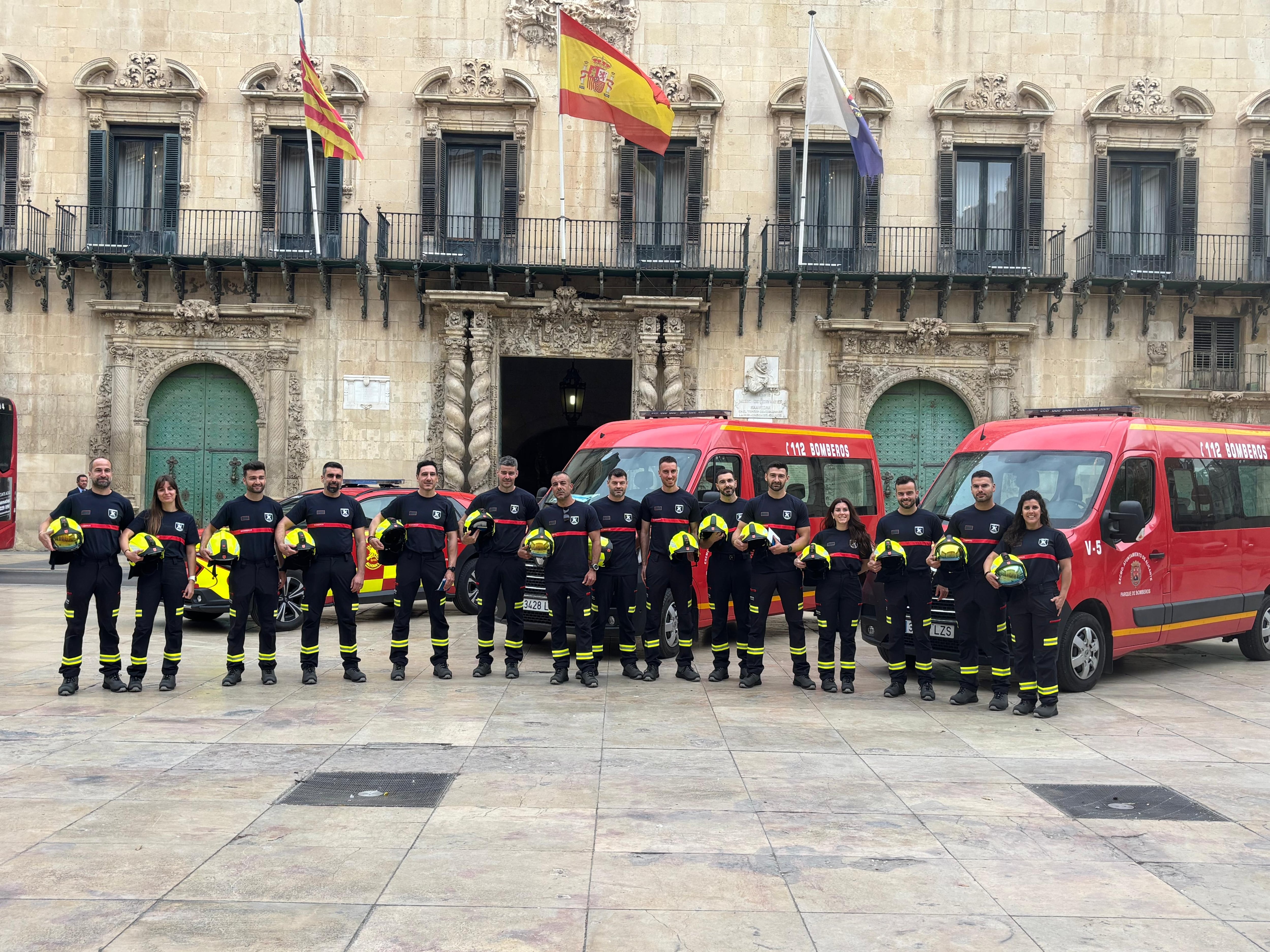 Los nuevos bomberos interinos posan junto a los vehículos que ha adquirido esta semana el Ayuntamiento de Alicante