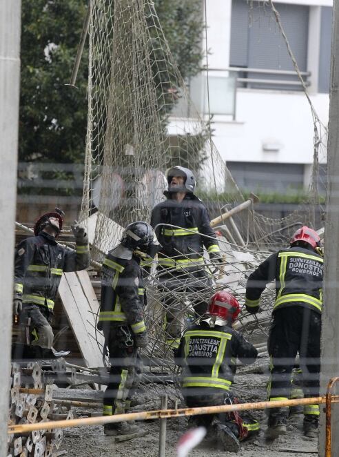 Efectivos del cuerpo de bomberos junto al andamio que se ha desplomado de un edificio de viviendas en construcción en San Sebastián