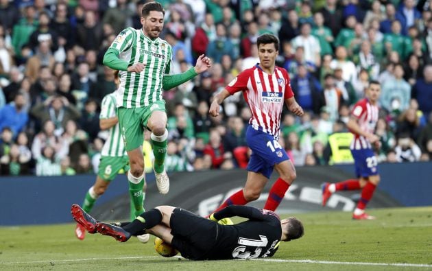 El defensa del Real Betis Javi García (i) salta por encima del portero del Atletico, Jan Oblak