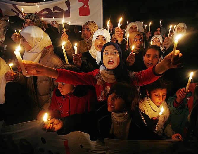 Niños palestinos sostienen velas durante la protesta por las restricciones