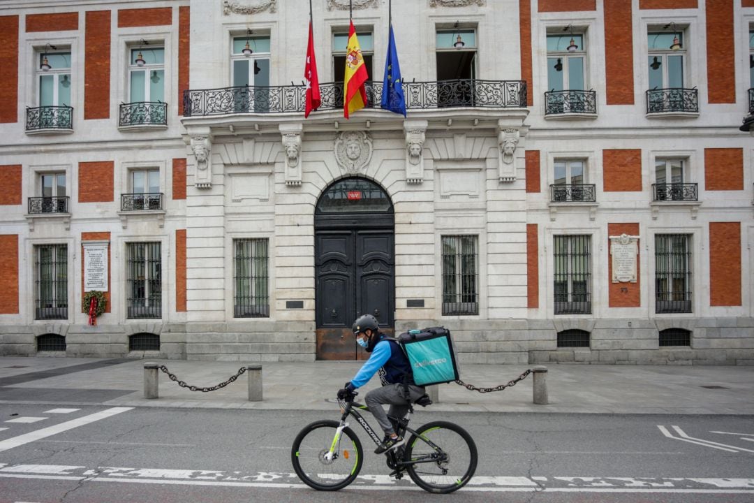 Un &#039;rider&#039; de Deliveroo circula por la Puerta del Sol, en Madrid (España) a 19 de abril de 2020.