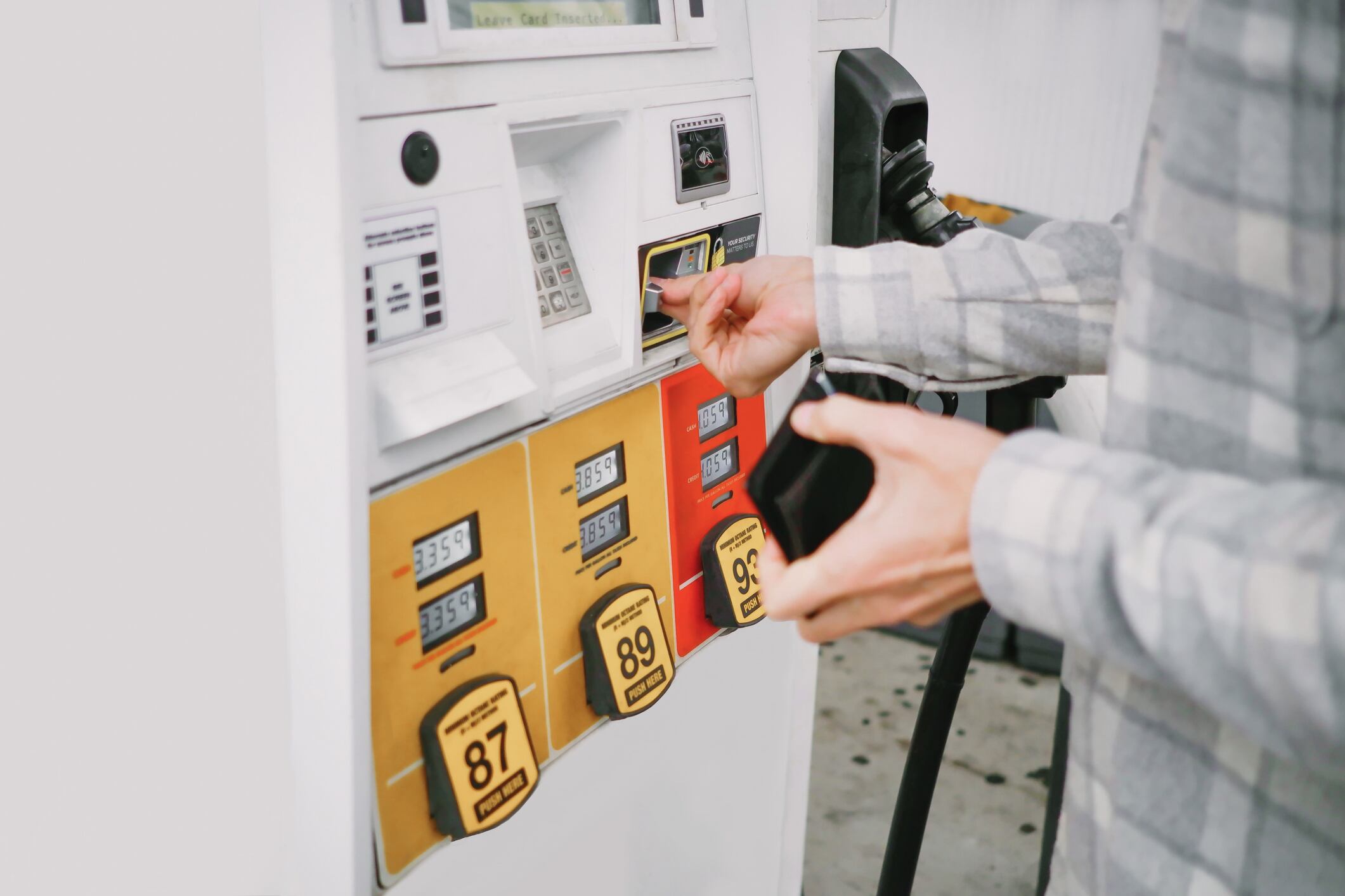 Un hombre ingresa dinero en una máquina para repostar gasolina