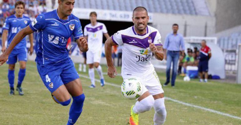 Dos futbolistas del Real Jaén y del Linares Deportivo se disputan el balón durante un derbi.