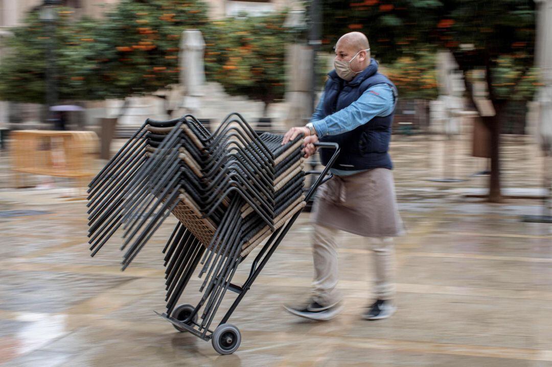 Un hostelero, instalando una terraza en la vía pública.