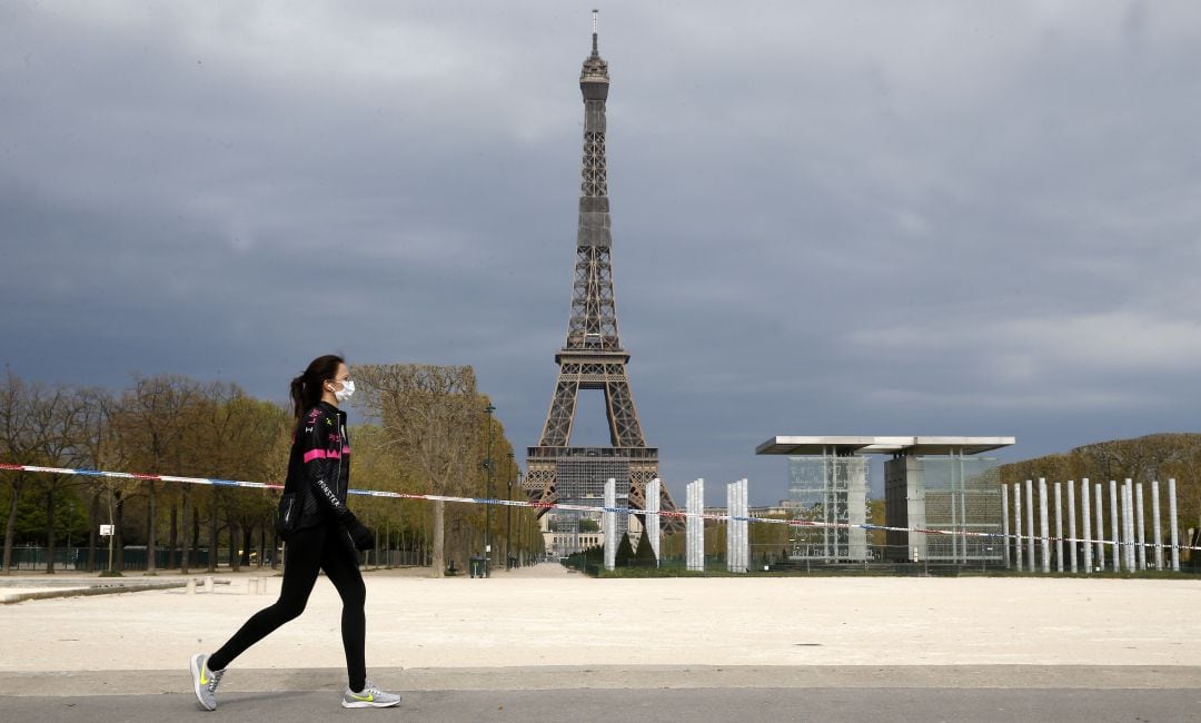 Una mujer haciendo deporte en París con mascarilla.