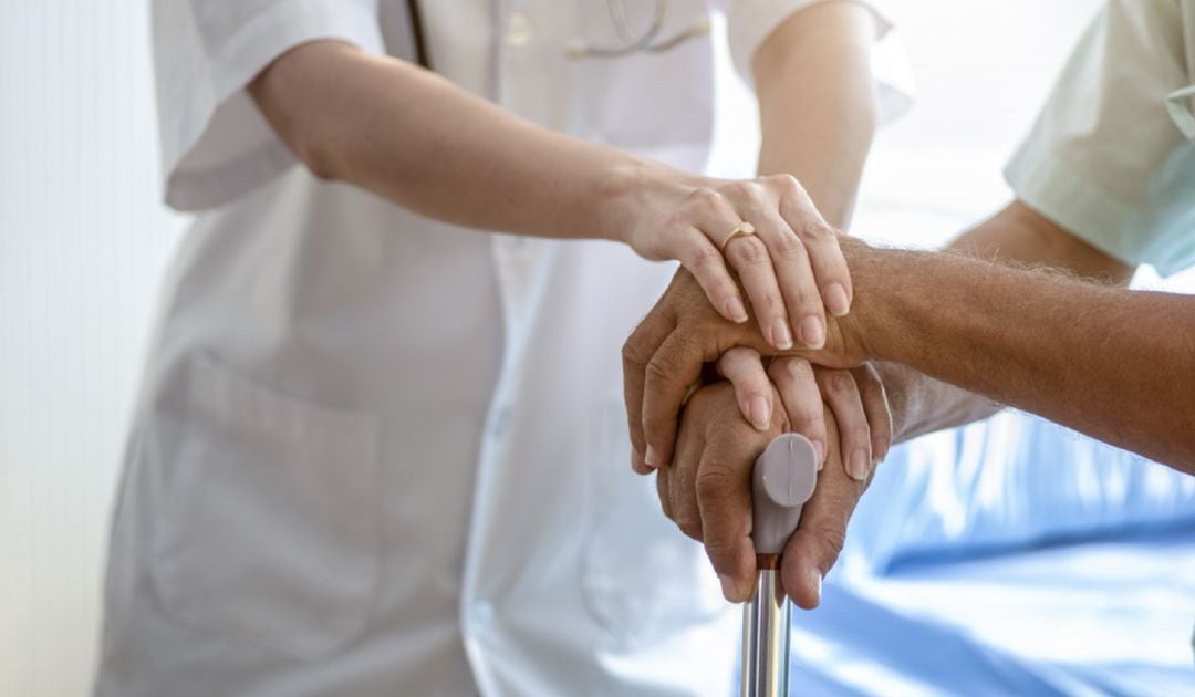 Manos de un anciano siendo consolado