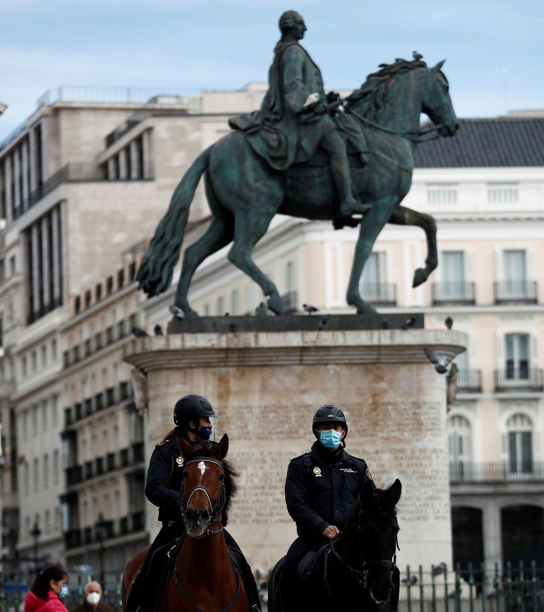 Varios agentes de policía a caballo patrullan por la Puerta del Sol de Madrid.