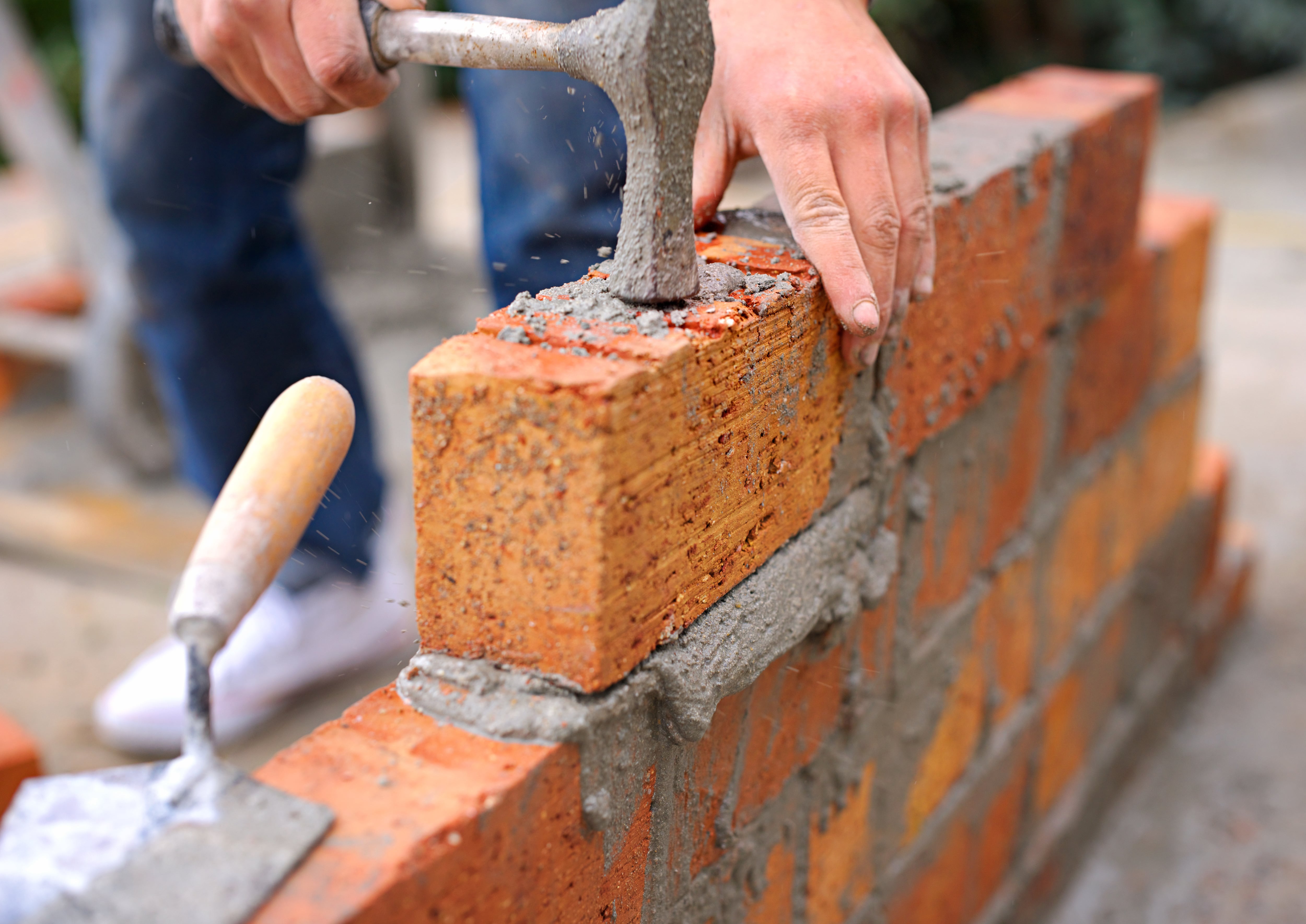 Laying the foundation one brick at a time. Shot of a master bricklayer at work