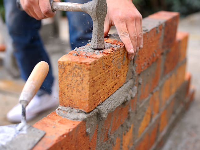Laying the foundation one brick at a time. Shot of a master bricklayer at work