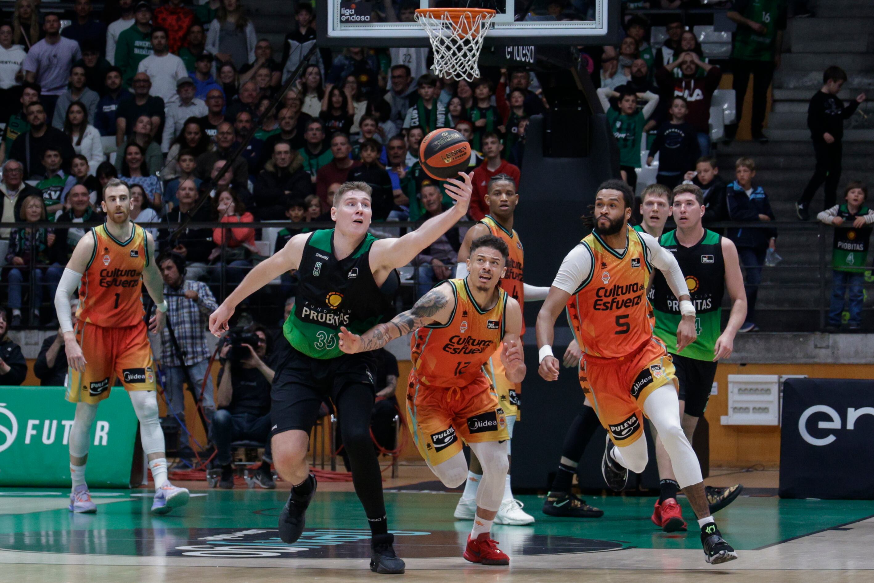 El base estadounidense del Valencia Basket Jonah Radebaugh (c) lucha con el pívot sueco del Joventut de Badalona Simon Birgander (i) durante el partido de la jornada 26 de la Liga Endesa disputado, esta tarde en el Pabellón Olímpico de Badalona entre el Joventut y Valencia Basket. EFE/ Quique García