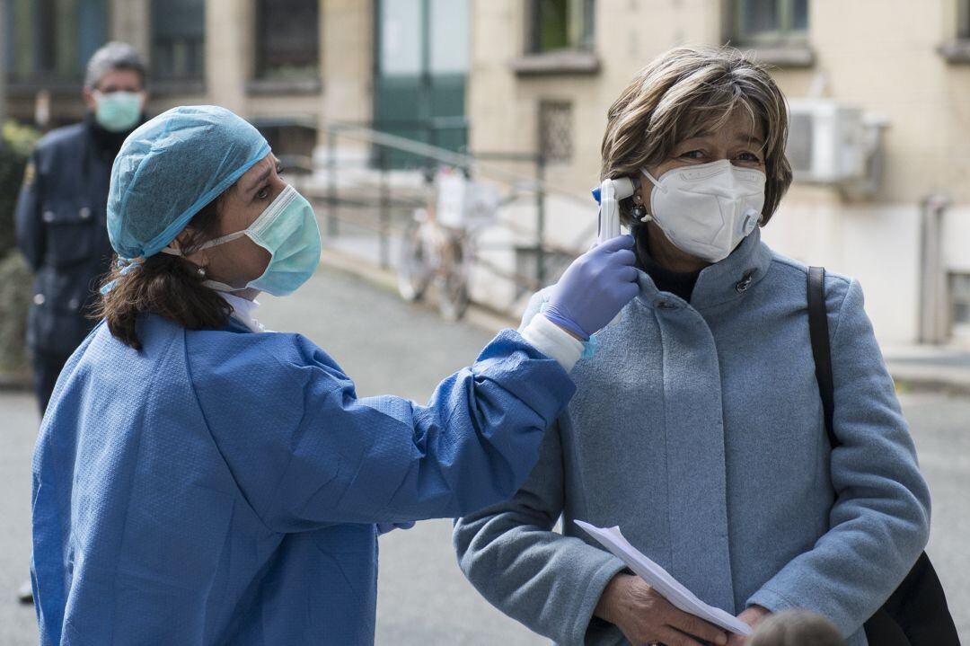 Personal médico comprueba la temperatura de una mujer 