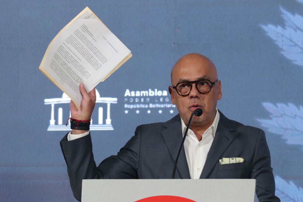 Fotografía cedida por la oficina de prensa de la Asamblea Nacional donde se observa al presidente del organismo, Jorge Rodriguez, sosteniendo una imagen durante una rueda de prensa