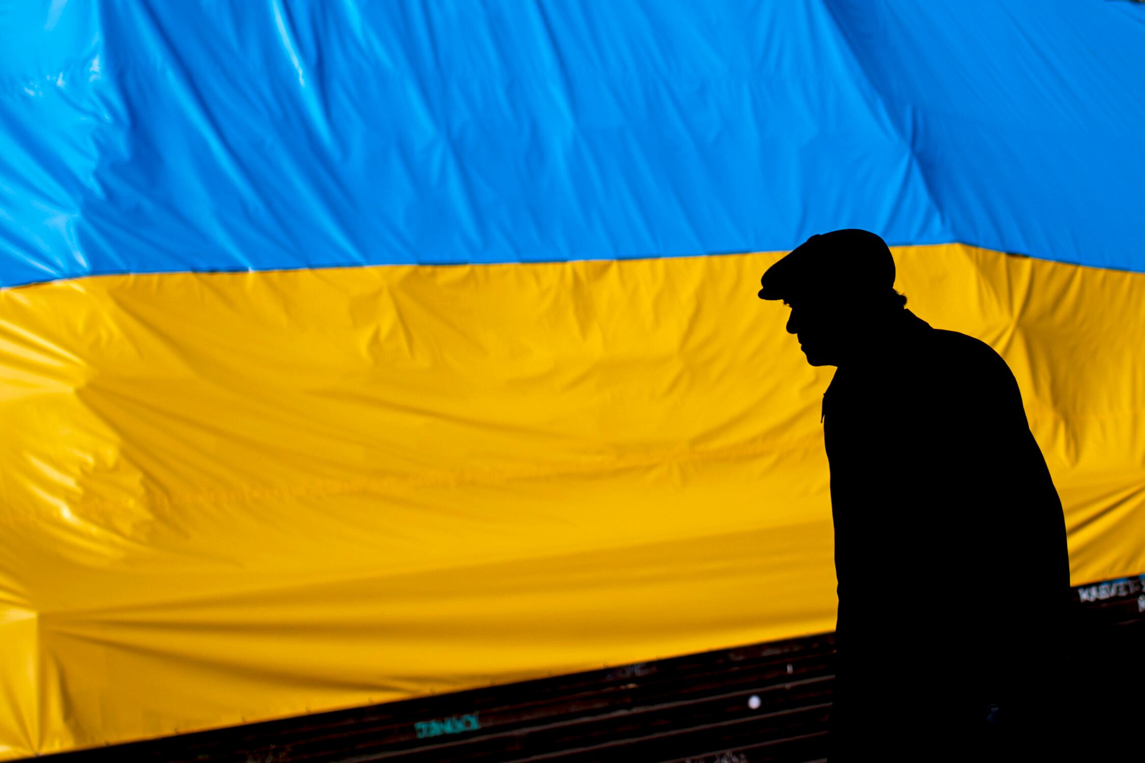 -FOTODELDÍA- PRAGUE, (REPÚBLICA CHECA), 08/03/2022.- Un hombre camina este martes frente a una bandera ucraniana en Praga, República Checa. Unos 100.000 refugiados de Ucrania han llegado a la República Checa, la mayoría de ellos son mujeres, niños y ancianos, desde el inicio de la invasión Rusia en Ucrania. EFE/ Martin Divisek
