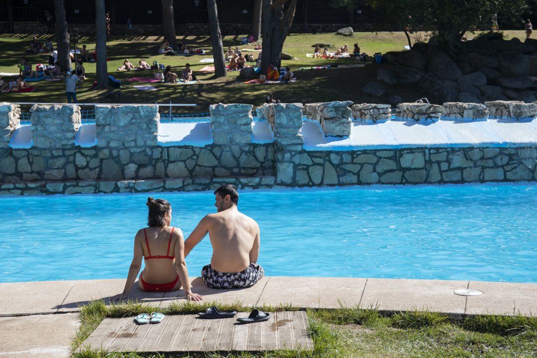 Un hombre y una mujer, en las piscinas de Las Berceas, a 21 de agosto de 2021, en Cercedilla, Madrid, (España).