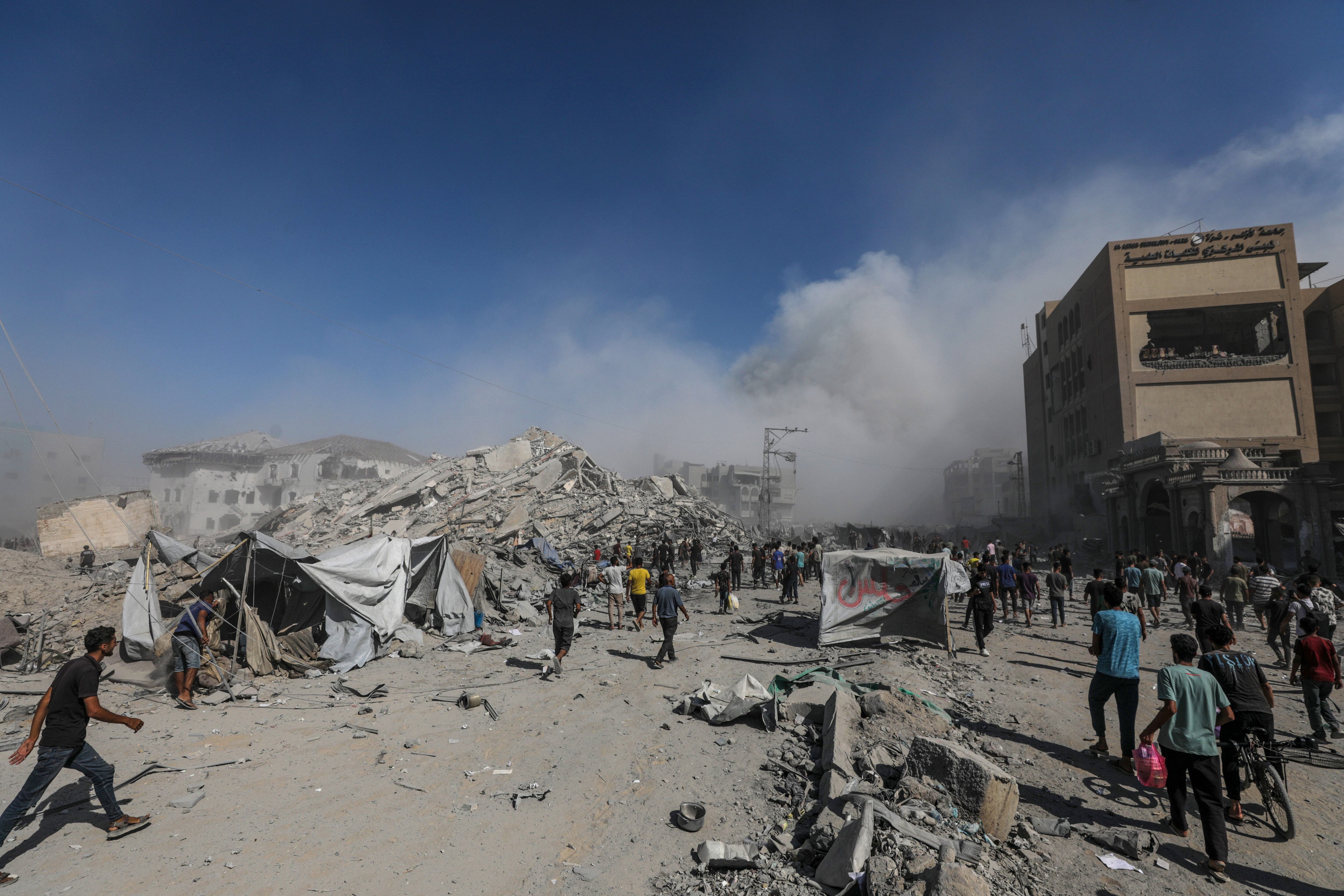 Palestinos caminan entre los escombros mientras el humo se eleva del edificio residencial al-Roya tras un ataque aéreo israelí en el oeste de la ciudad de Gaza, Franja de Gaza, 8 de septiembre de 2025.