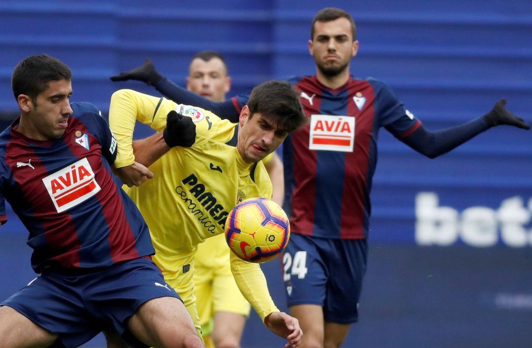 El jugador del Eibar José Ángel Valdés "Cote"  lucha un balón con el delantero del Villarreal Gerard Moreno, durante el partido de la jornada 18ª de LaLiga Santander, que ha disputado hoy en el estadio de Ipurúa de Eibar.