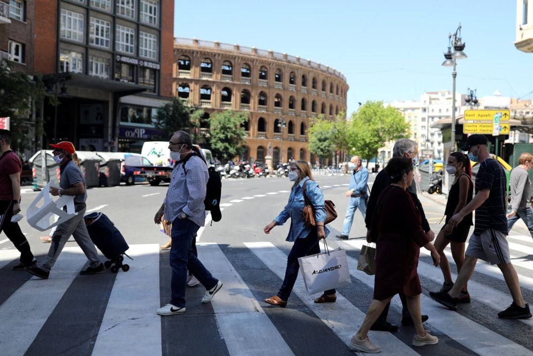 Gente cruzando en una de las centricas calles de València durante la fase 1