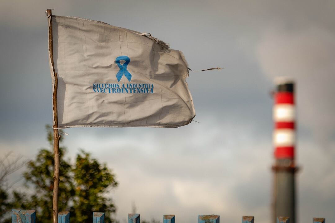 Una bandera reivindicativa ondea delante de la chimenea de la fábrica de Alcoa en San Cibrao, un día después de que los trabajadores alcanzaran un acuerdo con la empresa. Archivo.