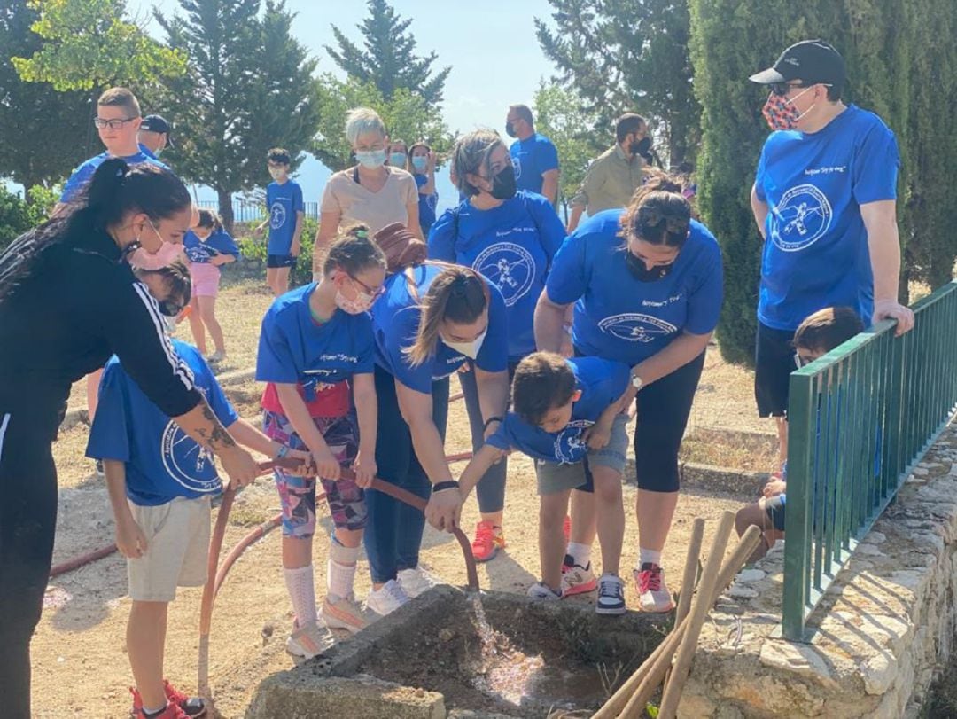 La alcaldesa, Mª Teresa García, segund por la derecha, ayuda a los niños y niñas en el riego