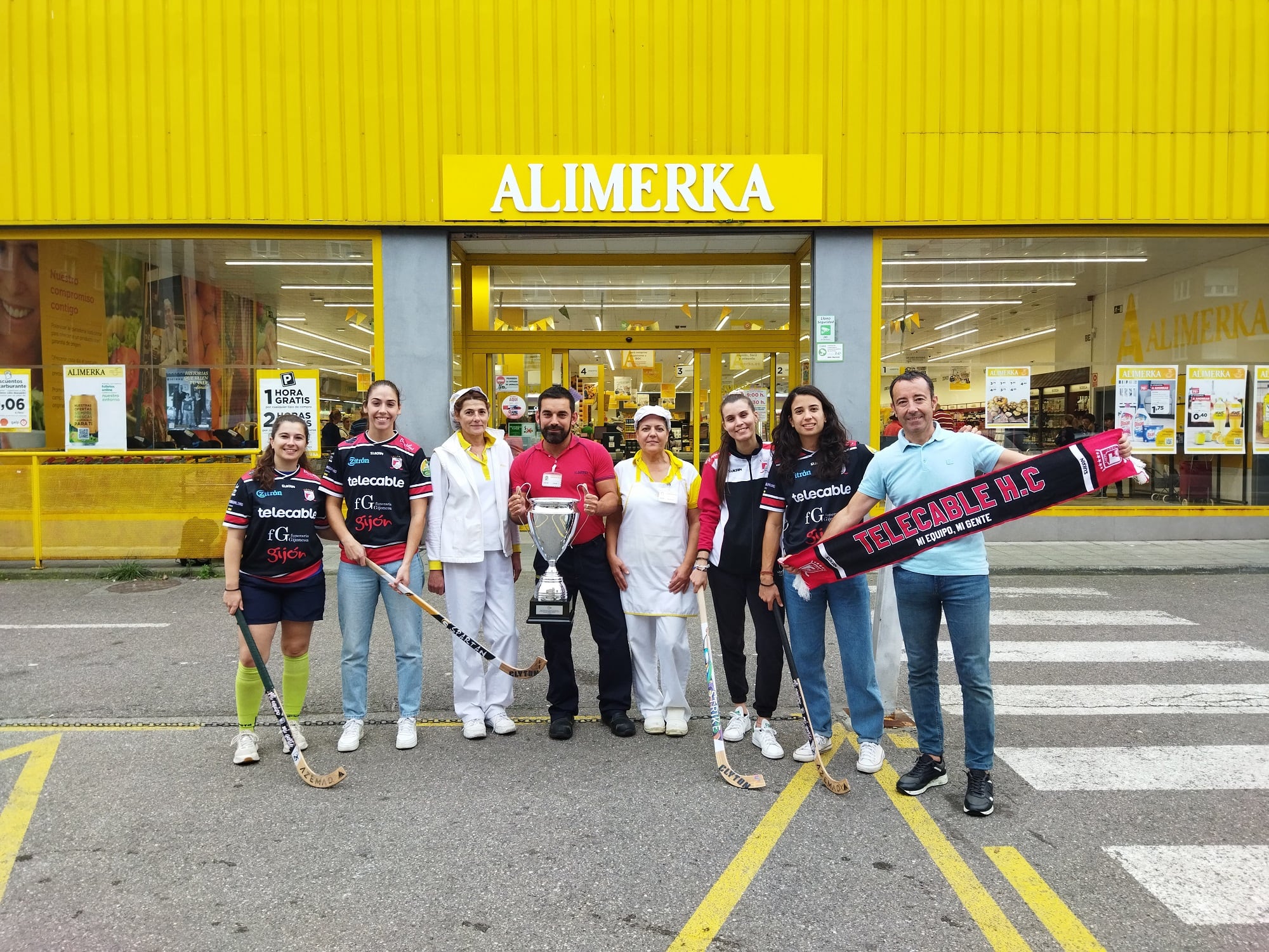 El entrenador y las jugadores del Telecable posan con trabajadores de Alimerka.