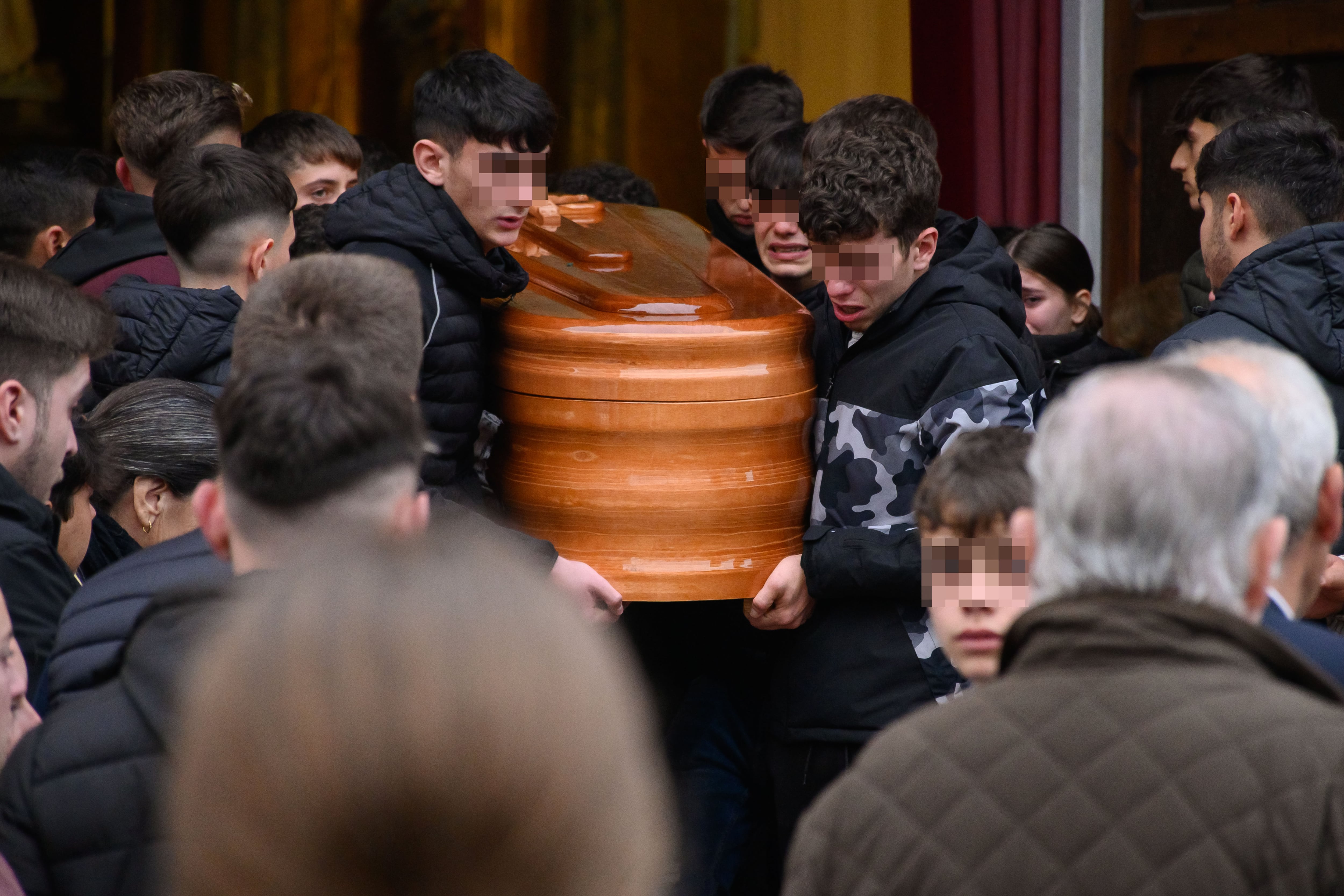 AZNALCOLLAR (SEVILLA), 10/01/2025.- Amigos y compañeros de Aarón, el joven de 17 años asesinado el pasado miércoles a la salida del instituto en Gerena (Sevilla), donde cursaba sus estudios, portan el féretro con los restos mortales del joven en el camino desde la Parroquia de Aznalcolla (Sevilla), su localidad natal, donde se ha celebrado la misa funeral. EFE/Raúl Caro
