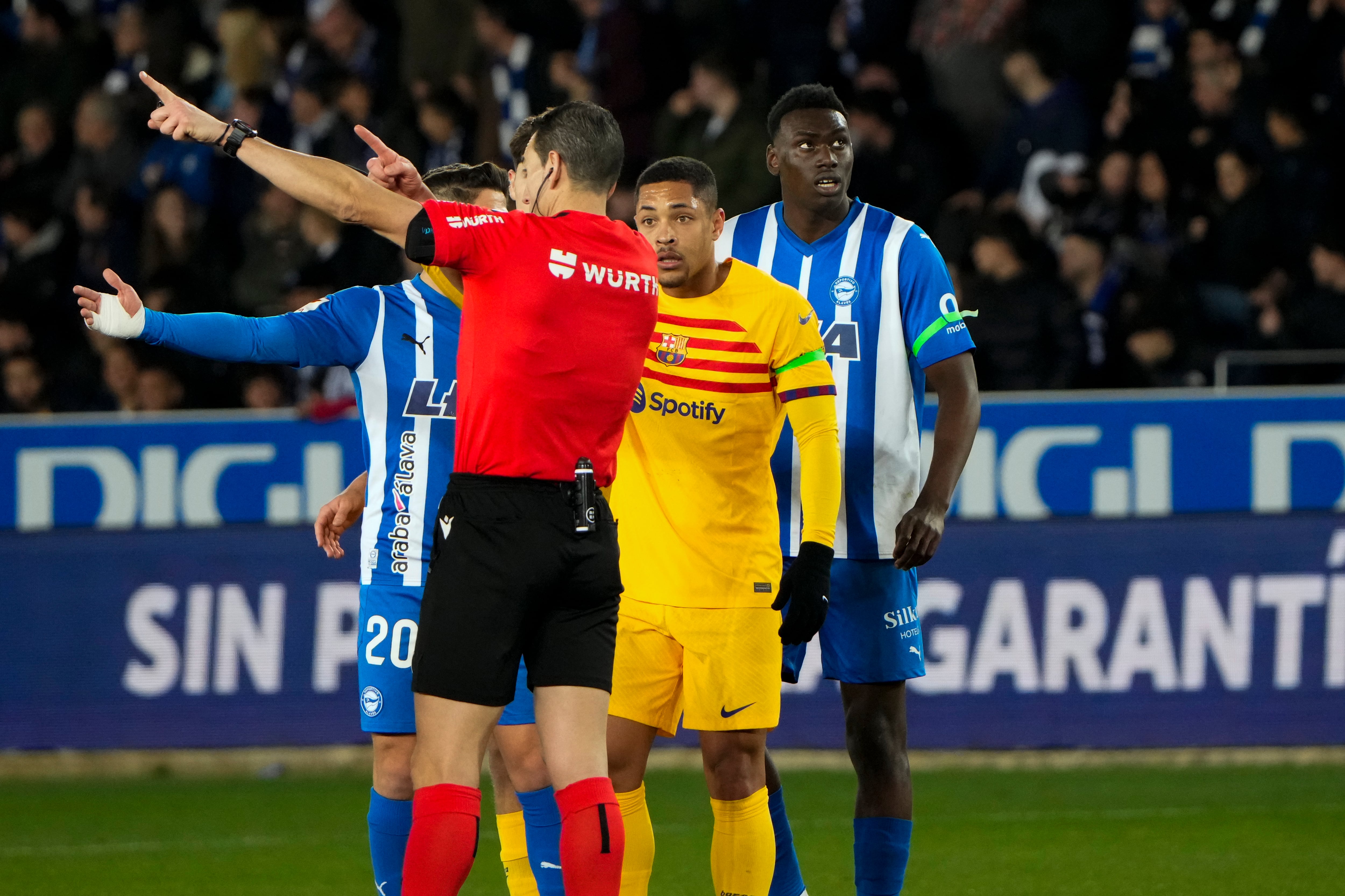 VITORIA, 03/02/2024.- El árbitro Martínez Munuera (i) y el delantero del Barcelona Vitor Roque (c), durante el partido de LaLiga de fútbol que Deportivo Alavés y FC Barcelona han disputado este sábado en el estadio de Mendizorrotza, en Vitoria. EFE/Adrián Ruiz Hierro
