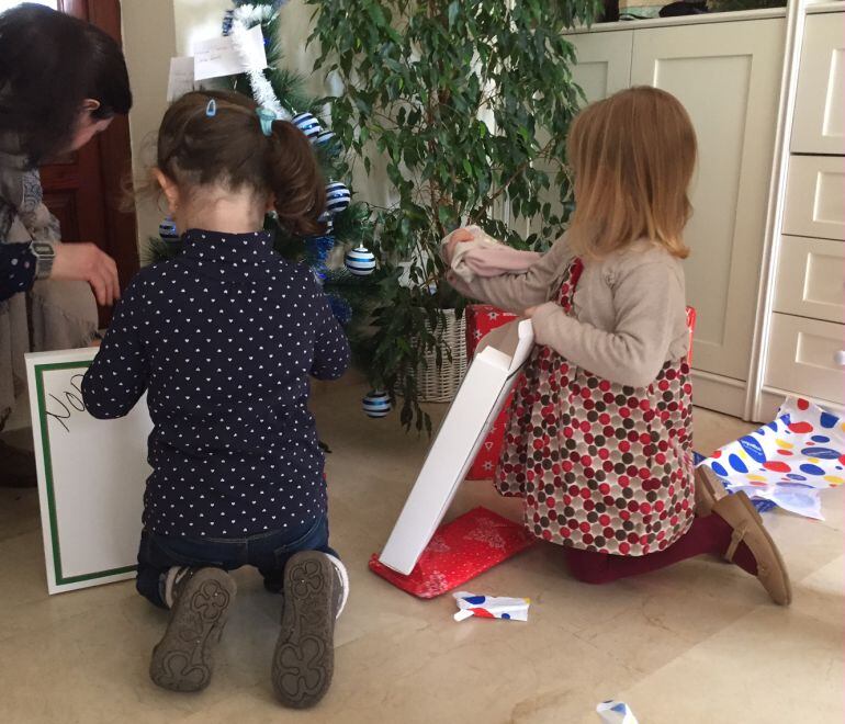 Dos pequeñas abren sus regalos de Reyes.