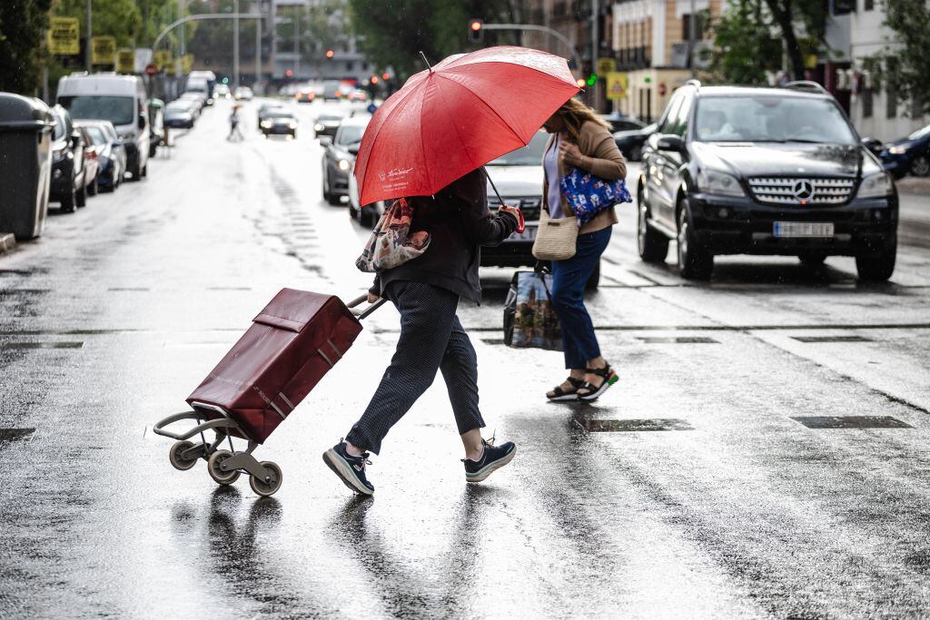 Varios viandantes se protegen de la lluvia en Madrid.