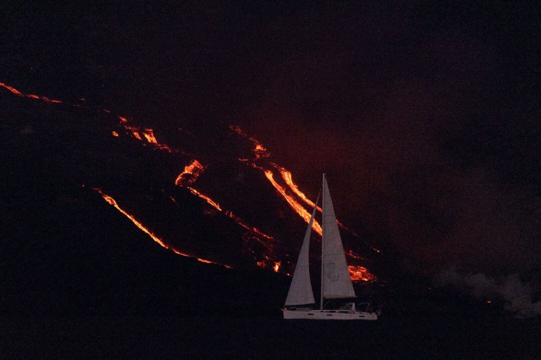 Un barco pasa frente a la lava del volcán de Cumbre Vieja en La Palma.