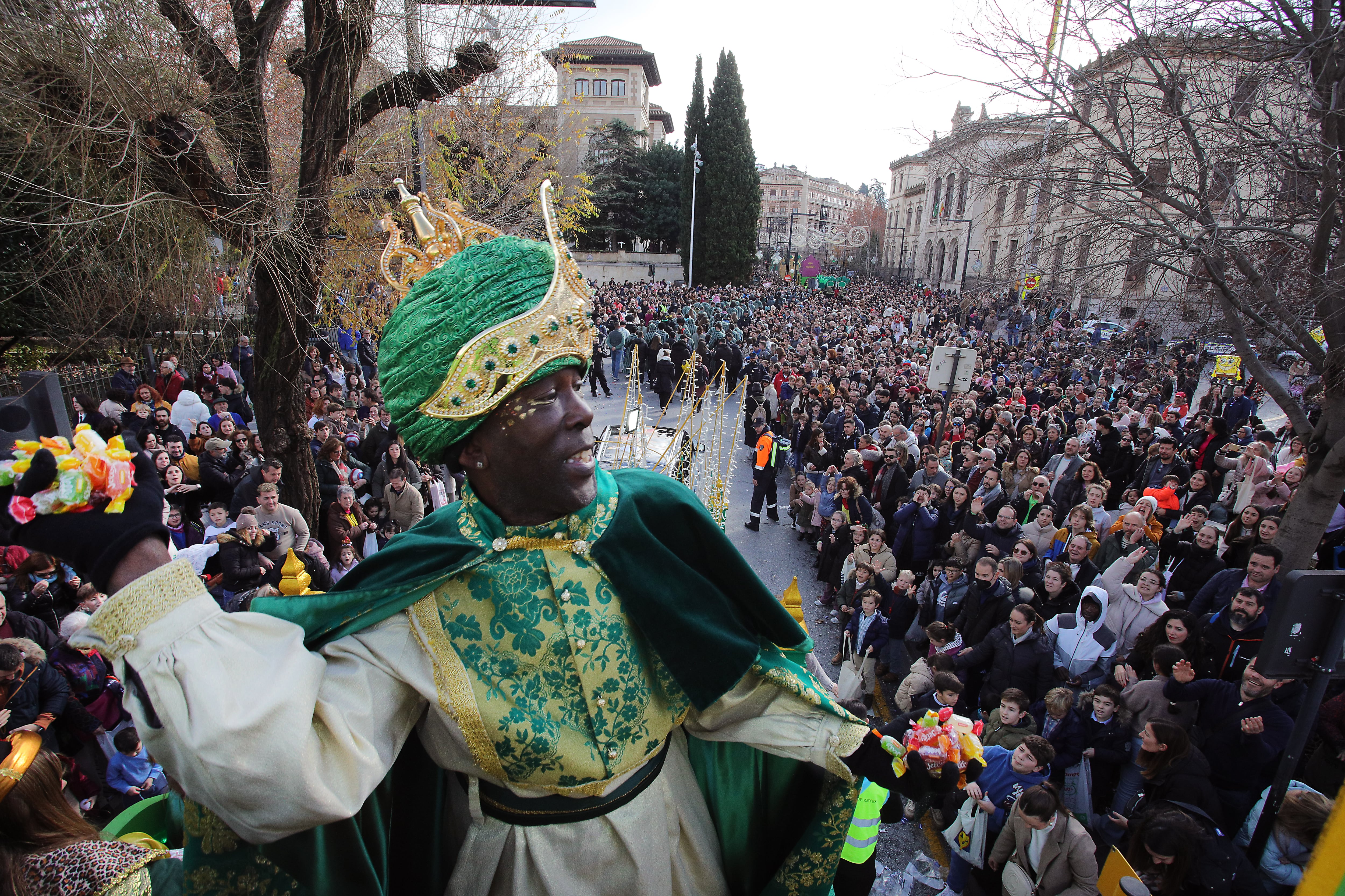 GRANADA, 05/01/2026.- El rey Baltasar lanza caramelos durante la cabalgata de los Reyes Magos de Granada que se ha adelantado este lunes debido a las condiciones meteorológicas. EFE/Pepe Torres