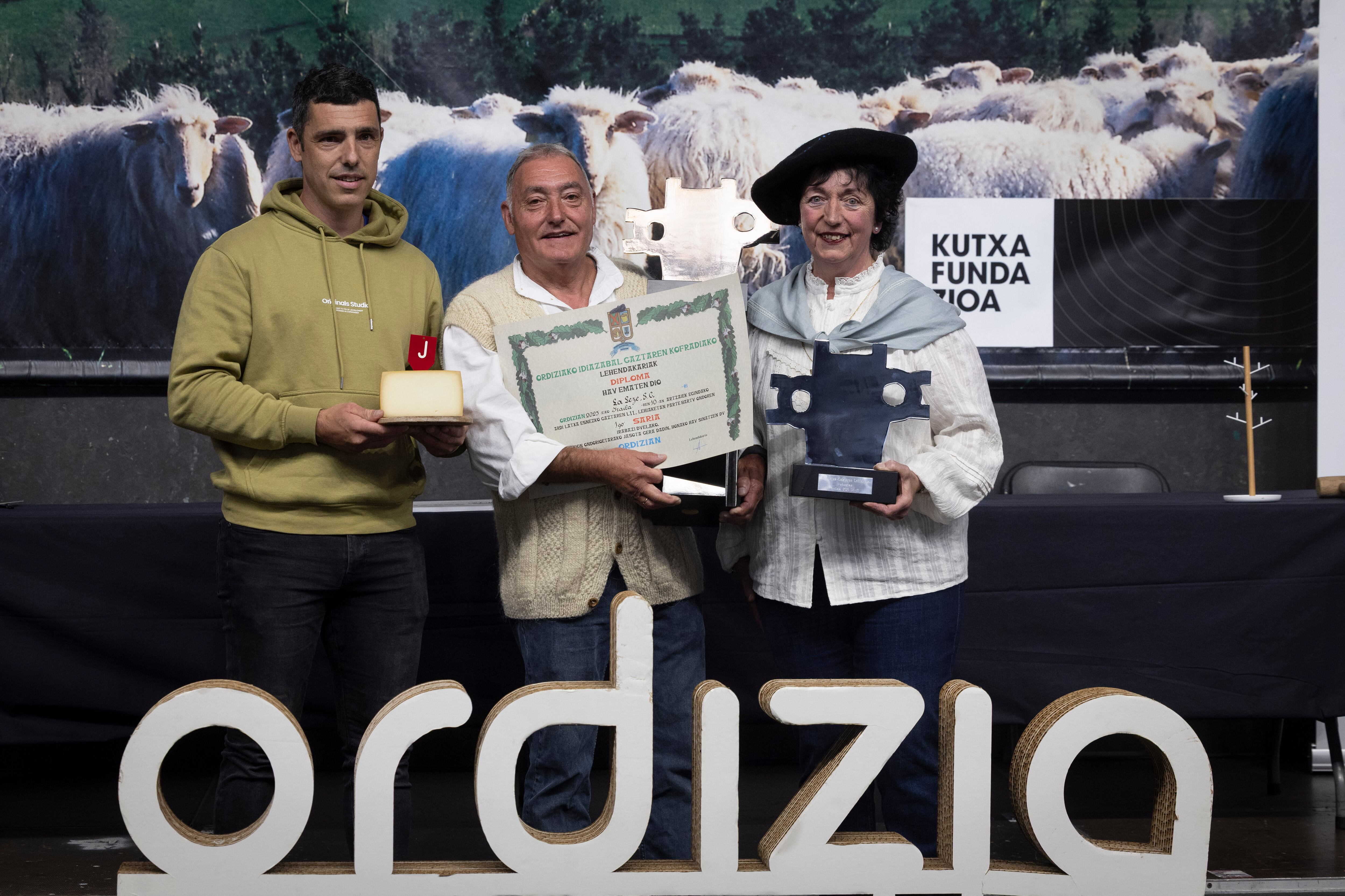 ORDIZIA (GIPUZKOA), 10/09/2025.- Eli Gorrotxategi (d) y Jose Mari Jauregi (c), de la quesería guipuzcoana La Leze, han sido los vencedores tras la celebración de 52 Concurso de Queso de leche de oveja latxa o carranzana de Ordizia (Gipuzkoa). EFE/Javier Etxezarreta
