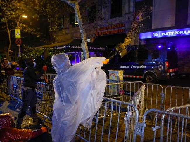 BARCELONA, 07/11/2024.- Un asistente lanza barro a la sede del PP de Barcelona durante la manifestación convocada este jueves por la izquierda independentista en protesta por la gestión de la dana. EFE/Toni Albir