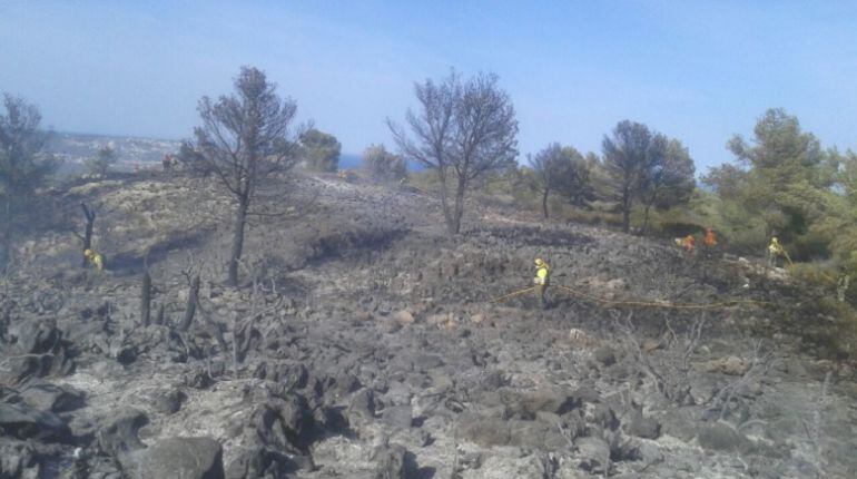 Efectivos de bomberos trabajando en la extinción del incendio forestal declarado en la zona de Cumbres del Sol de Benitatxell