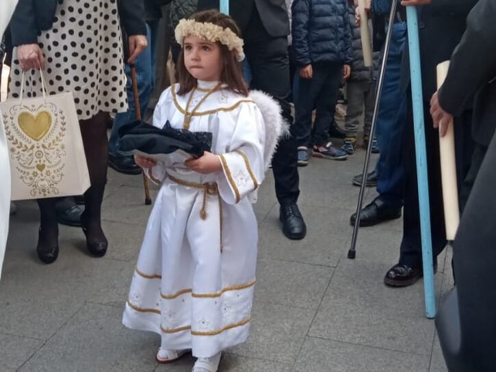 Valentina acompaña la procesión bajo las andas de la Virgen con el velo en las manos