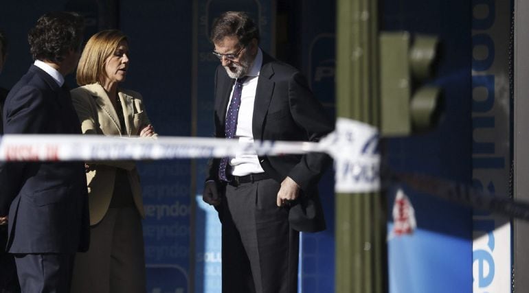 GRA205 MADRID 19/12/2014 El presidente del Gobierno español Mariano Rajoy (dch), la secretaria general del Partido Popular, María Dolores de Cospedal, y el vicesecretario de Organización del PP, Carlos Floriano, llegan a la sede del partido en Madrid, donde horas antes un hombre empotró un vehículo en el edificio. El coche, que conducía un hombre de 37 años que ha sido arrestado tras empotrar el vehículo, ha irrumpido en la sede del PP a través de la cristalera del esquinazo de Génova y ha atravesado la entrada hasta llegar a la escalera que conduce a la primera planta. EFE/JAVIER LIZÓN