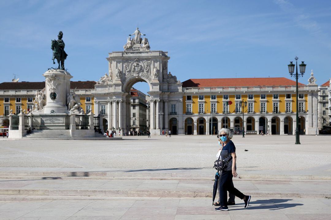 Dos personas pasean con mascarilla por el centro de Lisboa