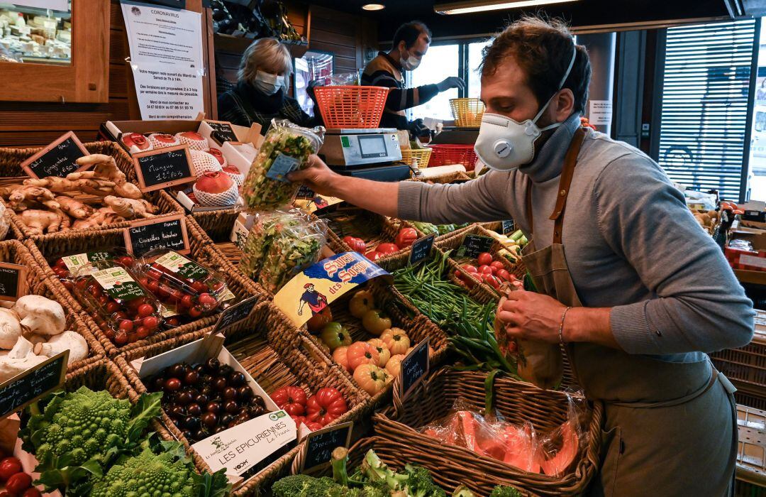 Un frutero coloca los productos en el escaparate.