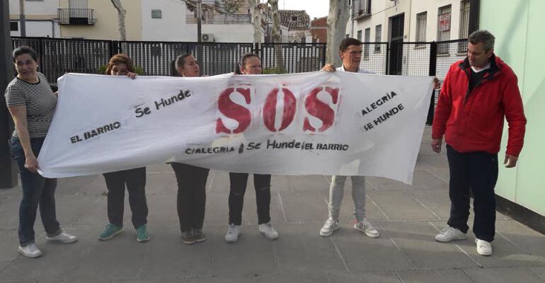 Varios vecinos sujetan una pancarta en la plaza de los Rosales para denunciar el estado del barrio.