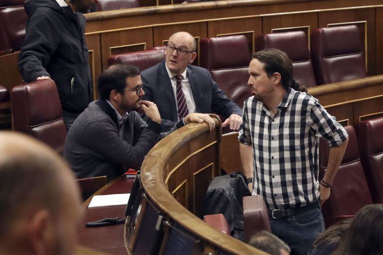 El secretario general de Podemos, Pablo Iglesias (d). conversa con el líder de IU, Alberto Garzón, durante el pleno del Congreso 