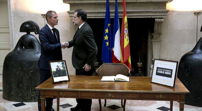 El presidente del Gobierno, Mariano Rajoy, saluda al embajador francés, Jérôme Bonnafont, tras firmar en el libro de condolencias que se ha abierto en la Embajada francesa en Madrid por las víctimas del ataque contra el semanario francés &#039;Charlie Hebdo&#039;.