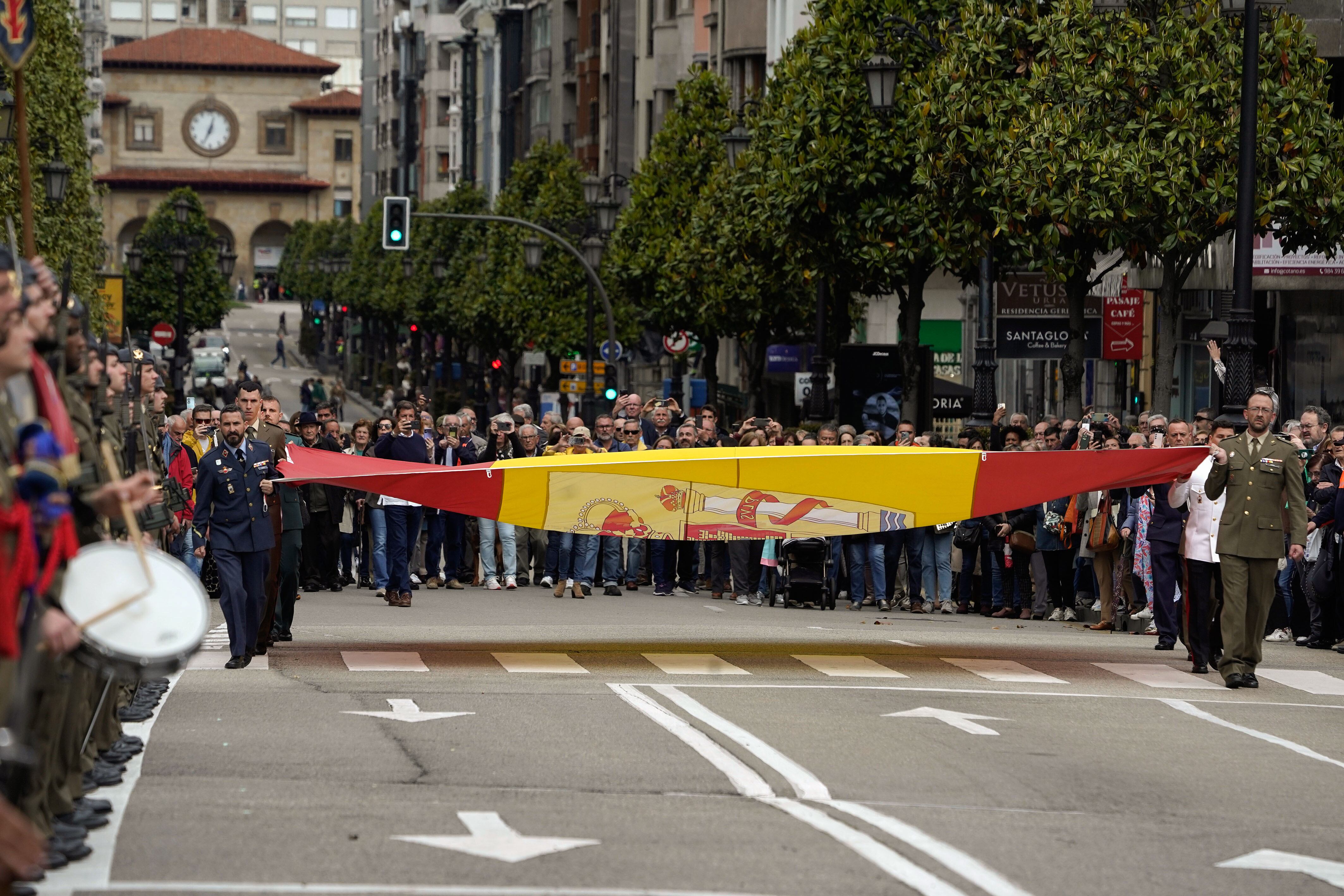 Los militares izan la bandera de España con motivo del Día de las Fuerzas Armadas, este miércoles en la calle Uría de Oviedo. Gijón y Oviedo acogen desde hoy las actividades organizadas con motivo de la celebración del Día de las Fuerzas Armadas 2024, cuyo desfile central se desarrollará el sábado en la capital del Principado bajo la presidencia de los reyes con la participación de 3.250 soldados, trece acorazados y más de un centenar de vehículos. EFE/ Paco Paredes